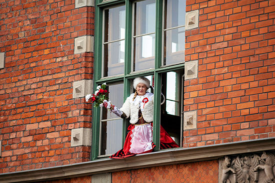 سيدة بولندية تشاهد احتفالية يوم الاستقلال من نافذة منزلها
