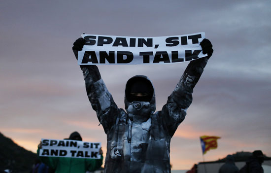 متظاهر-يحمل-لافتة-مناهضة-لأسبانيا