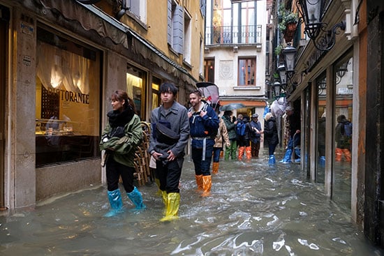 سكان المدينة الإيطالية يحاولون عبور المياه