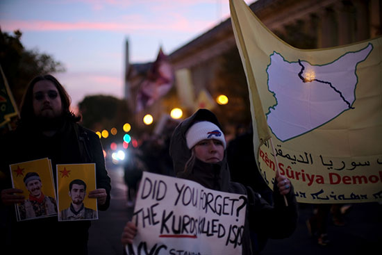 المحتجون يرفعون علم لقوات سوريا الديمقراطية