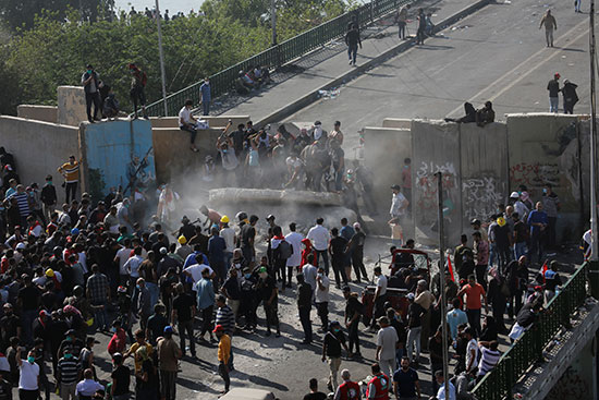 Demonstrators demolish concrete barriers