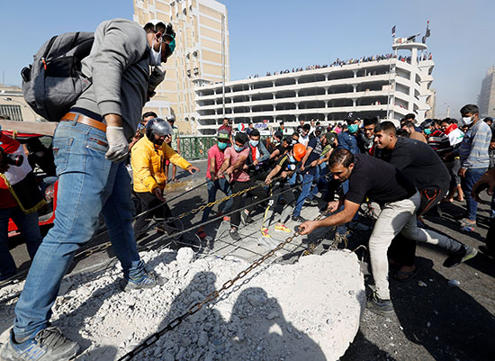 Demonstrators remove concrete barriers