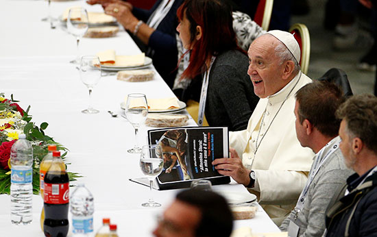 بابا الفاتيكان يجلس وسط الحضور ويطالع إحدى المجلات
