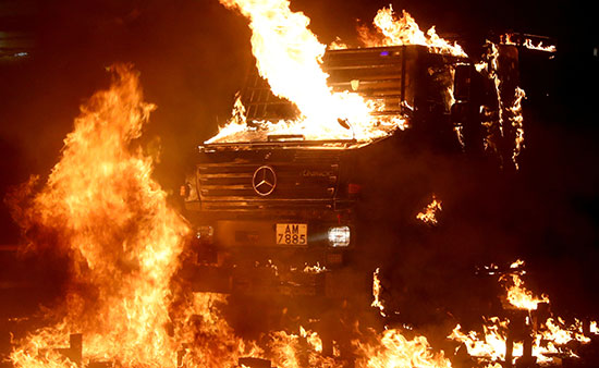 متظاهرون يشعلون النيران فى سيارة شرطة