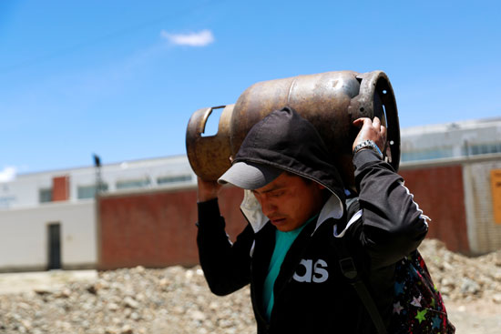 مواطن بوليفي يحمل أنبوبة فارغة