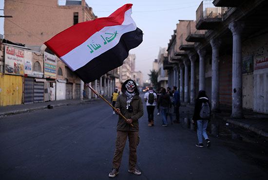 متظاهر يرفع العلم العراقى