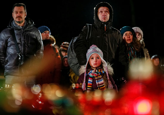 ام تصطحب طفلتها لزيارة النصب التذكارى لضحايا الابادة فى كييف