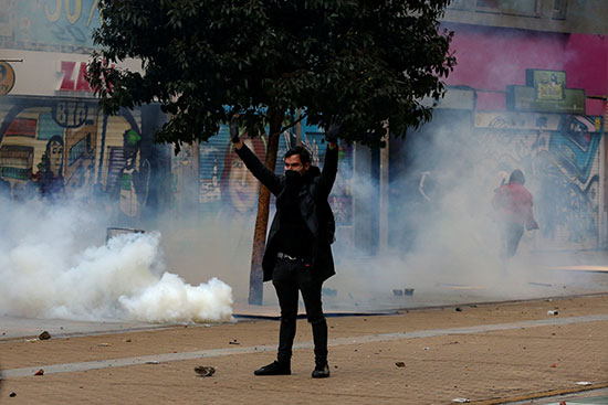 متظاهر يقف وسط الغاز المسيل للدموع