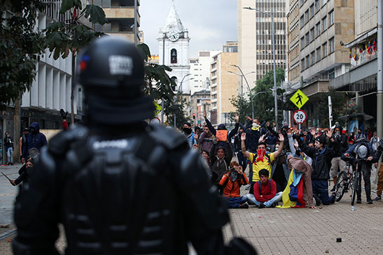 شرطى يواجه مجموعة متظاهرين فى كولومبيا