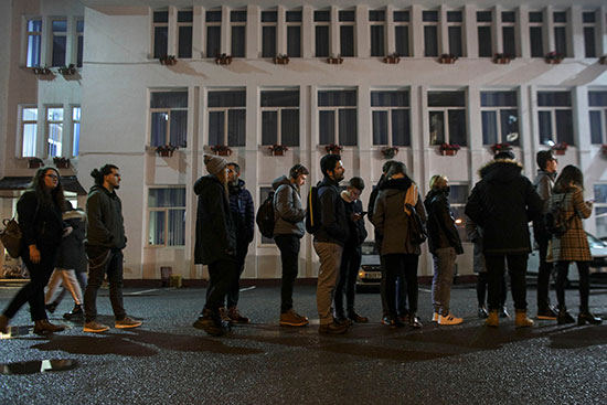 طلاب الجامعات الرومانية يقفون في صف واحد أثناء انتظارهم للإدلاء بأصواتهم
