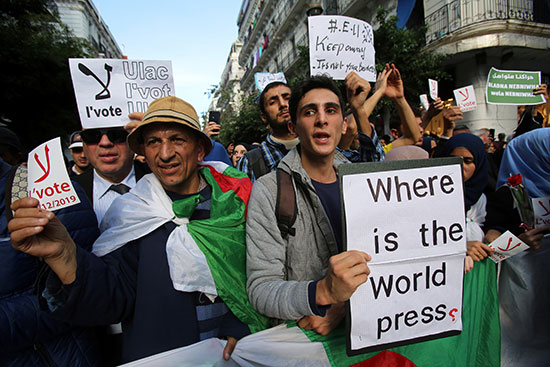المتظاهرون يحملون لافتات وأعلام خلال احتجاج يرفضون انتخابات ديسمبر الرئاسية في الجزائر العاصمة (2)