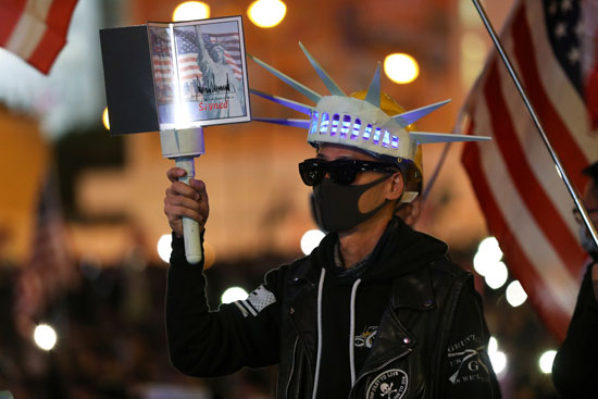 متظاهر يحمل صورة تمثال الحرية