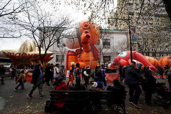 الناس يسيرون بجوار بالونات التضخم في عيد الشكر في نيويورك