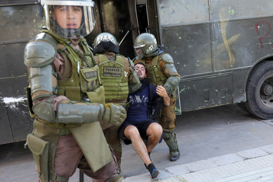 قوات الأمن فى تشيلى يعتقلون أحد المتظاهرين