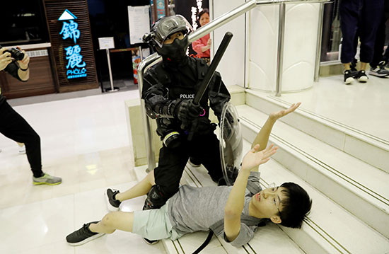 فرد أمن من شرطة هونج كونج يتعامل مع محتج مناهض للحكومة فى مركز تجاري في تاي بو