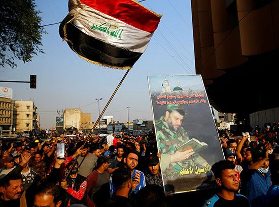 المتظاهرون يرفعون الأعلام العراقية