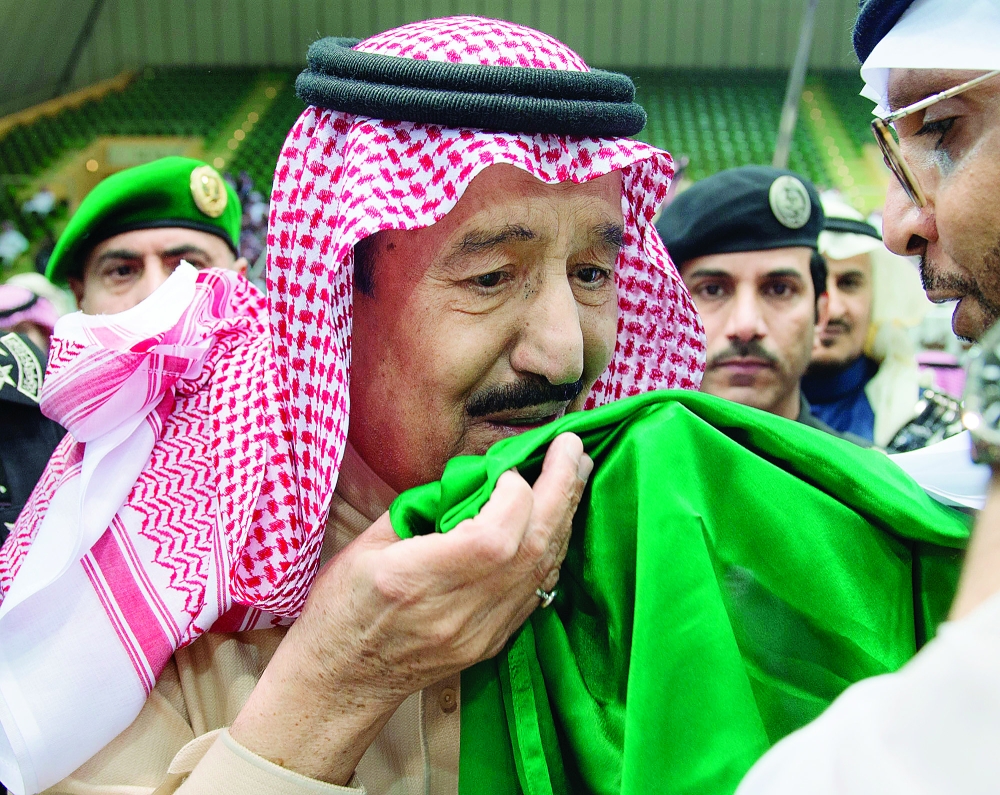 الملك سلمان بن عبدالعزيز يقبل علم بلاده