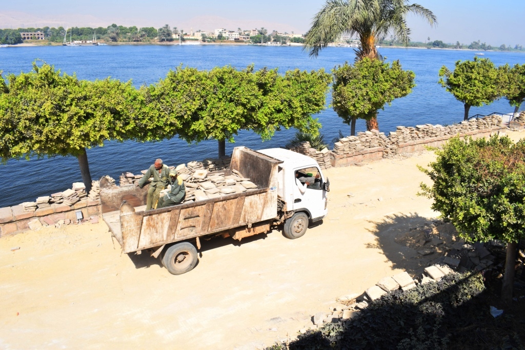 شاهد عمال مدينة الأقصر يواصلون العمل في الممشي السفلي من كورنيش النيل  (1)