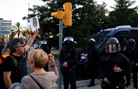 متظاهر يرفع صورة مقلوبة للملك فى وجه أفراد الشرطة