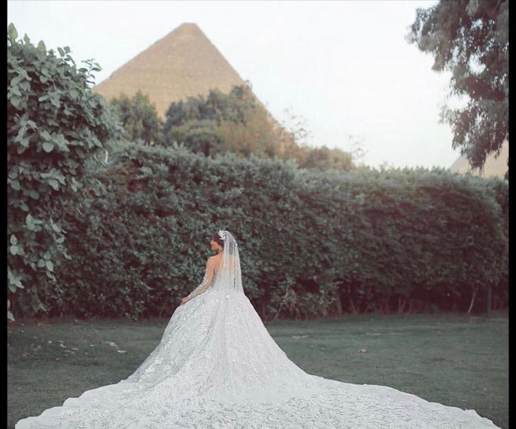 عروس تستعرض فستانها أمام الأهرامات