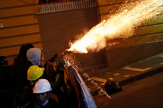 متظاهرون يلقون الألعاب النارية على قوات الأمن
