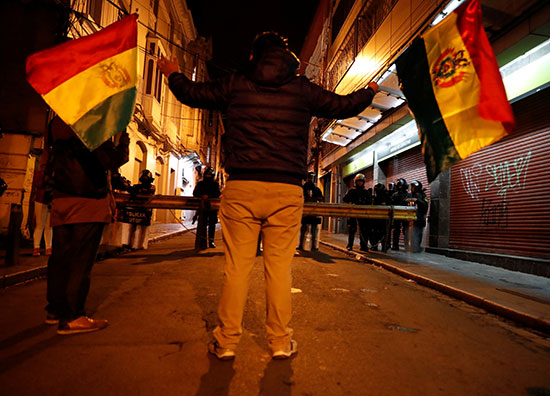 متظاهر بوليفى يرفع علم بلاده