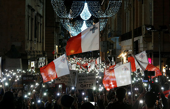 متظاهرون يحملون أعلام مالطا خلال الاحتجاجات