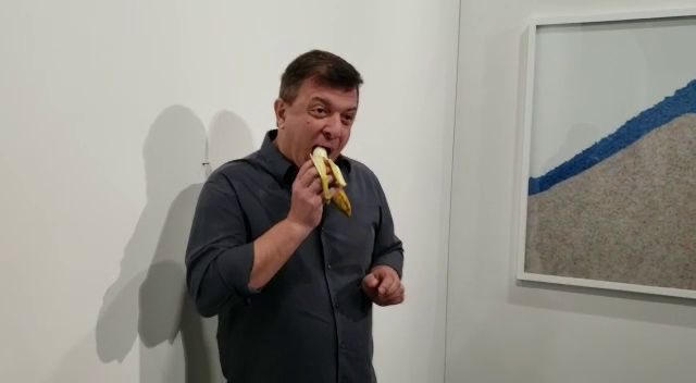 الفنان التشكيلى ديفيد داتونا يأكل الموزة على الحائط