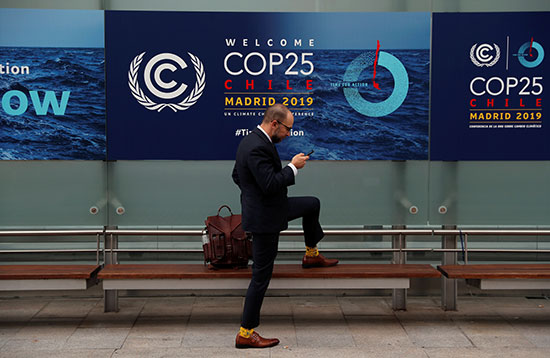 أحد المشاركين يستخدم هاتفه في مؤتمر الأمم المتحدة المعني بتغير المناخ