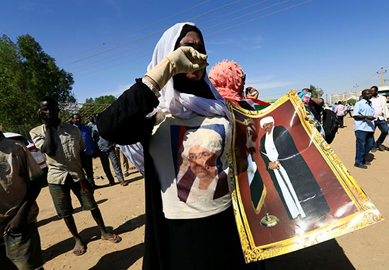 متظاهرة تحمل صورة للرئيس السودانى المعزول عمر البشير