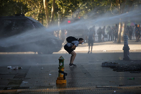 متظاهر يتجنب المياه التى تطلقها الشرطة