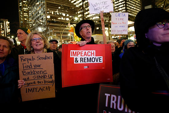 المتظاهرون يحملون لافتات تدعو إلى عزل وإقالة الرئيس الأمريكى