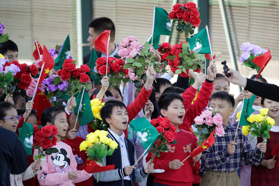 أطفال-بالإقليم-يرفعون-أعلام-الصين-وماكاو