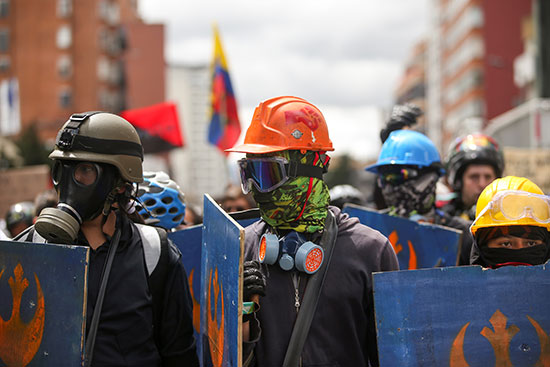 المحتجون يمسكون بدروع خلال الإضراب فى بوجوتا