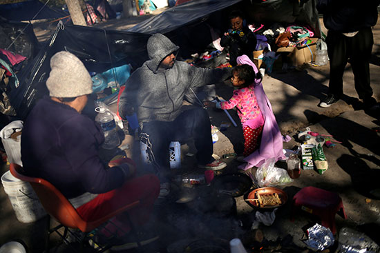 طالبو اللجوء المكسيكيون يجلسون خارج خيامهم مع انخفاض درجات الحرارة إلى ما دون الصفر