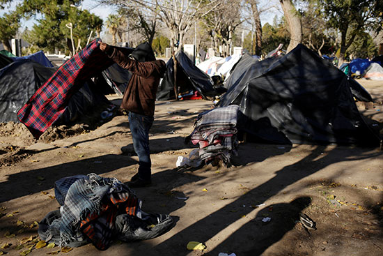 طالب لجوء مكسيكي يحزم أمتعته للانتقال إلى مأوى حيث انخفضت درجات الحرارة