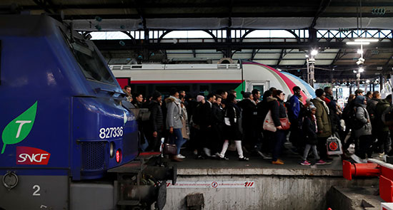 يمشي الركاب على منصة في محطة سان لازار للسكك الحديدية أثناء إضراب من جميع نقابات عمال SNCF