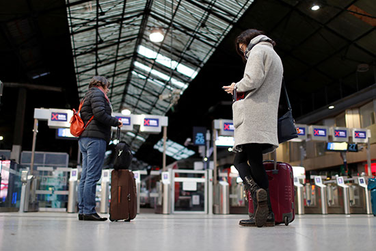 المسافرون ينشغلون فى هواتفهم المحمولة انتظارا لوصول القطارات