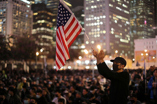 احد المتظاهرين يرفع العلم الامريكى