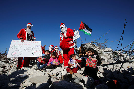 متظاهرون وأطفال فوق أنقاض منزل هدمته قوات الإحتلال الإسرائيلى فى الضفة الغربية