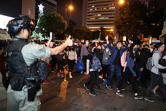 تبادل التحيات بعلامة النصر بين أحد أفراد الشرطة والمتظاهرين