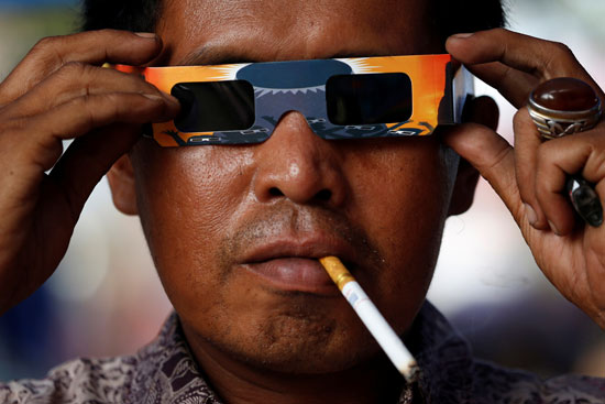 مواطن إندونيسيى يرتدى نظارة كسوف الشمس