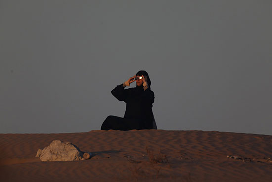 امرأة إماراتية تشاهد كسوف حلقي شمسي في مدينة زايد في منطقة الظفرة في أبو ظبي