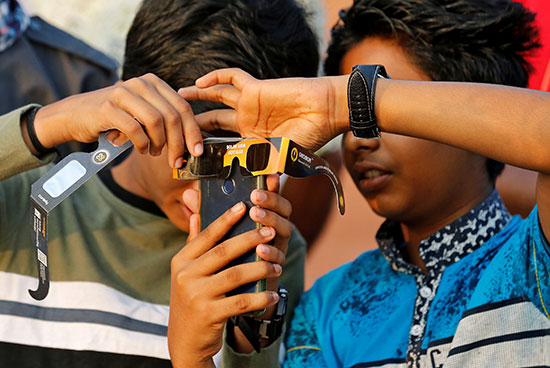 الأطفال يستخدمون هواتفهم المحمولة  لالتقاط صور لكسوف الشمس