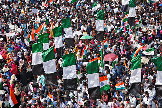 المتظاهرون يحملون الأعلام واللافتات أثناء حضورهم مظاهرة احتجاج