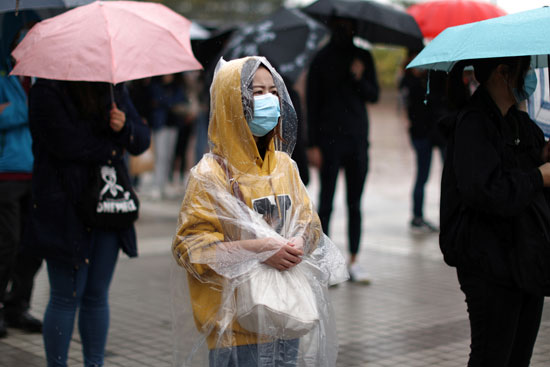 فتاة تقف وسط الأمطار خلال مظاهرات هونج كونج