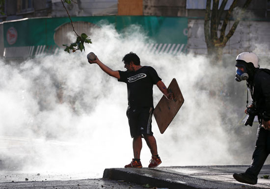 متظاهر يحمل صخرة أثناء احتجاج ضد حكومة تشيلى