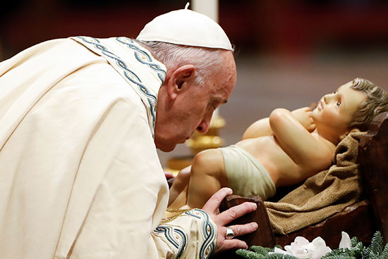 البابا فرانسيس يقبل تمثالا للطفل يسوع وهو يقود صلاة صلاة الغروب