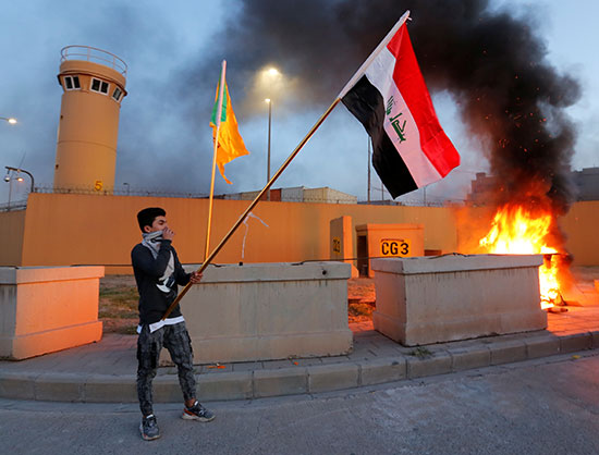 أحدا المتظاهرين يرفع العلم العراقى اثناء احتجاج امام السفارة الامريكية