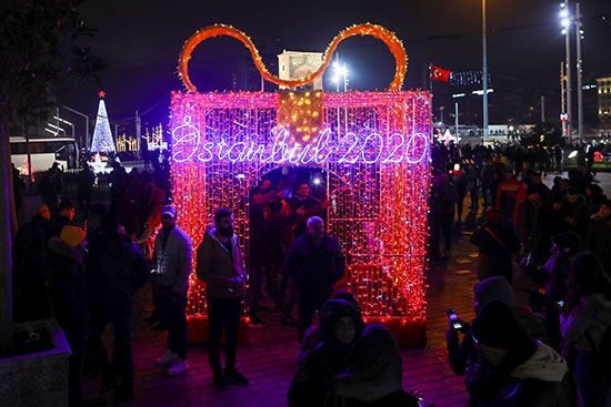 لناس يتجولون في ميدان تقسيم خلال احتفالات ليلة رأس السنة في إسطنبول
